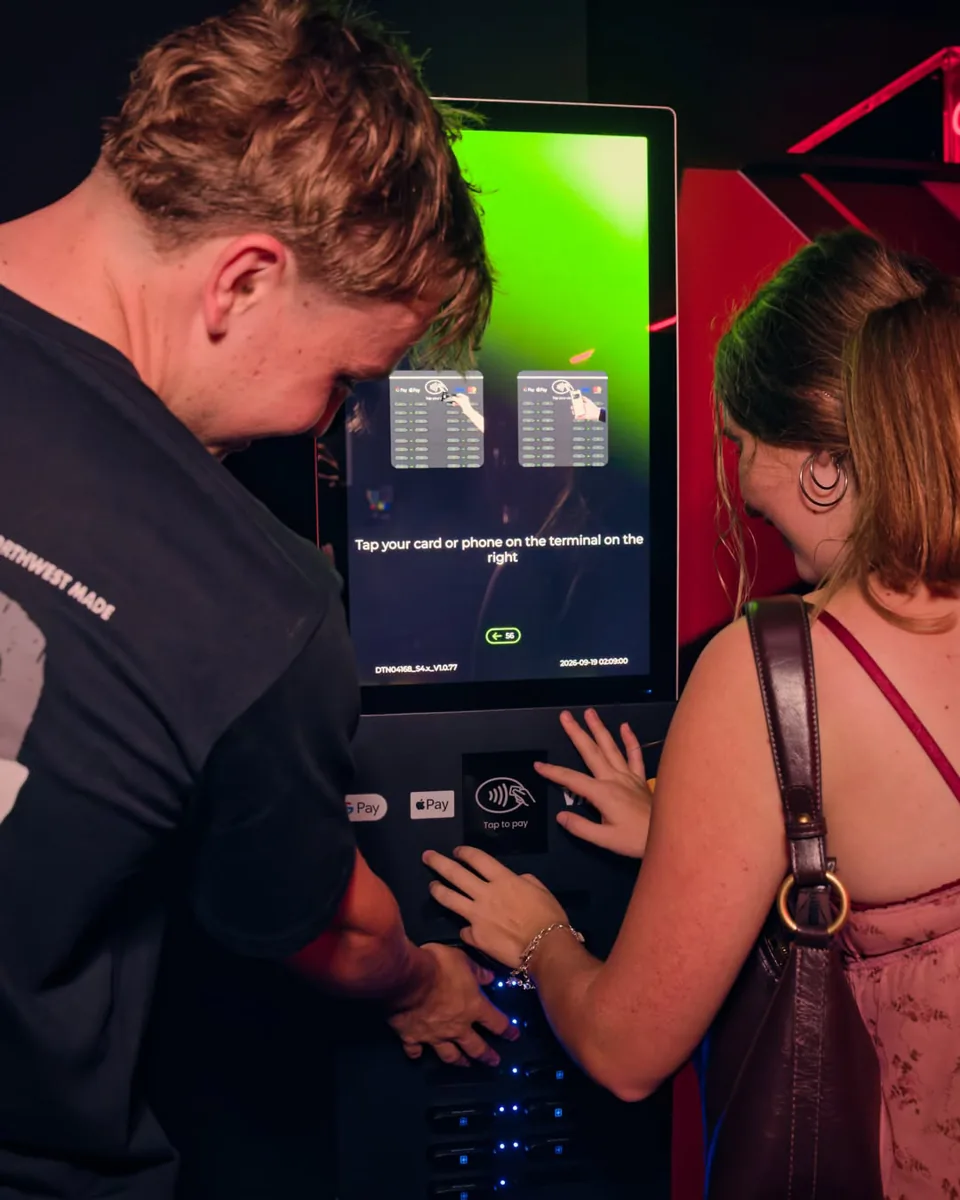 Two guests using the payment terminal on a ZapDock power bank station